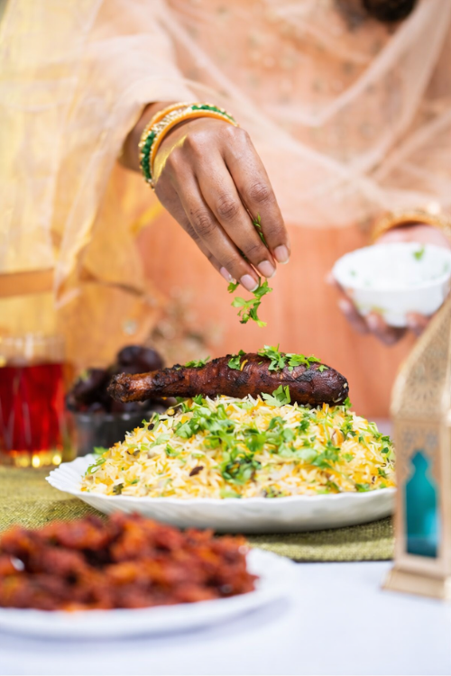 Adding fresh cilantro to biryani